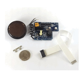Ultrasonic sensor kit including sensor grill, circuit board, ribbon cable, metal clip, and quarter coin for size reference.