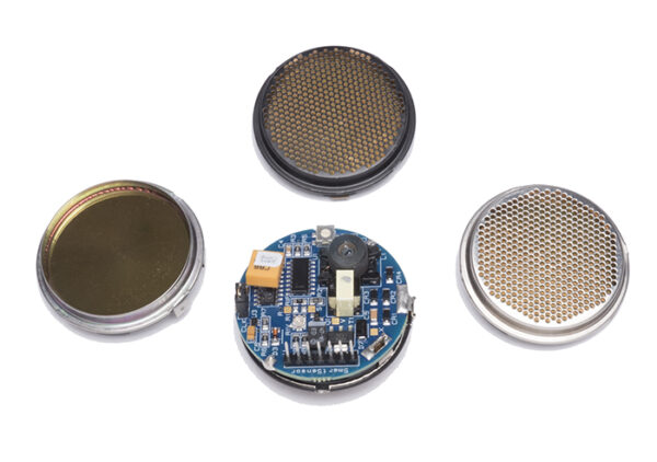 Exploded view of ultrasonic sensor showing three metal mesh grill covers and one circular circuit board with electronic components, displayed on a white background.