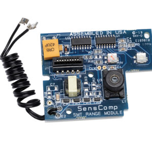 Rectangular blue SensComp ultrasonic range module circuit board with various electronic components, a coiled black wire, and visible text labels.