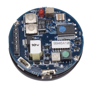 Close-up of circular ultrasonic sensor PCB featuring electronic chips, capacitors, connectors, and labeled stickers, displayed on a white background.