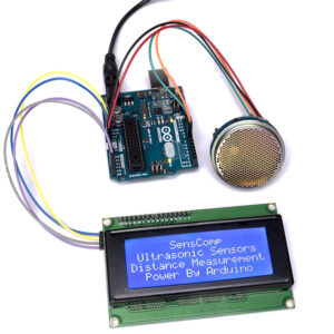 Arduino setup with ultrasonic sensor module connected to a blue LCD screen displaying SensComp distance measurement text.