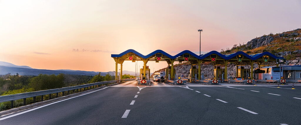 Multiple toll lanes at a highway checkpoint during sunset