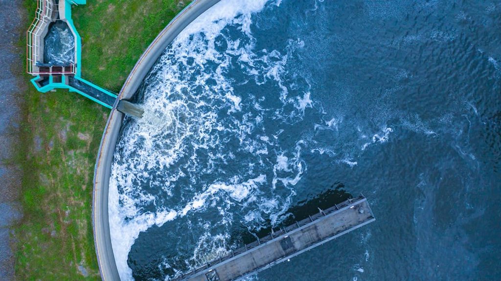 Aerial view of aerated water churning at the edge of a circular clarifier, a continuous level monitoring application for electrostatic ultrasonic transducers
