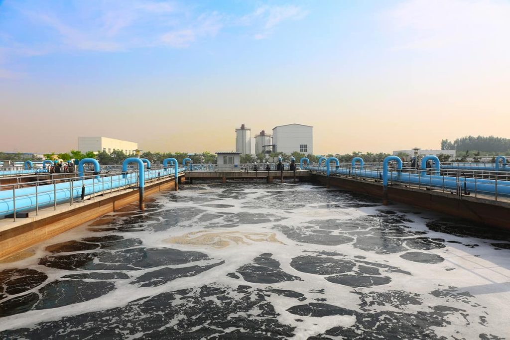 Thick foam covering an aeration basin at a water treatment plant, the kind of surface electrostatic ultrasonic transducers measure through