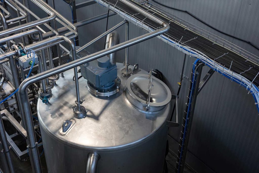 Stainless steel process tank with top-mounted agitator and sanitary piping, a liquid level application for electrostatic ultrasonic transducers