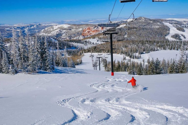 Ski run with tracked fresh powder below a chairlift, where electrostatic ultrasonic transducers track snow depth