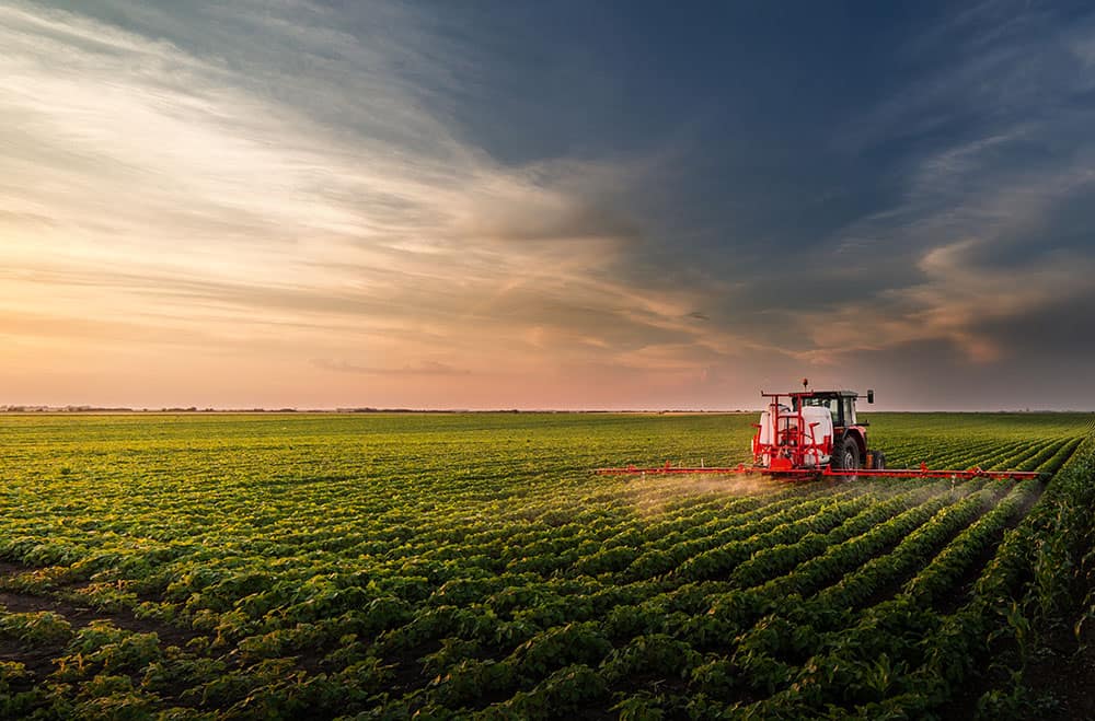 Tractor using ultrasonic sensors to determine spray height
