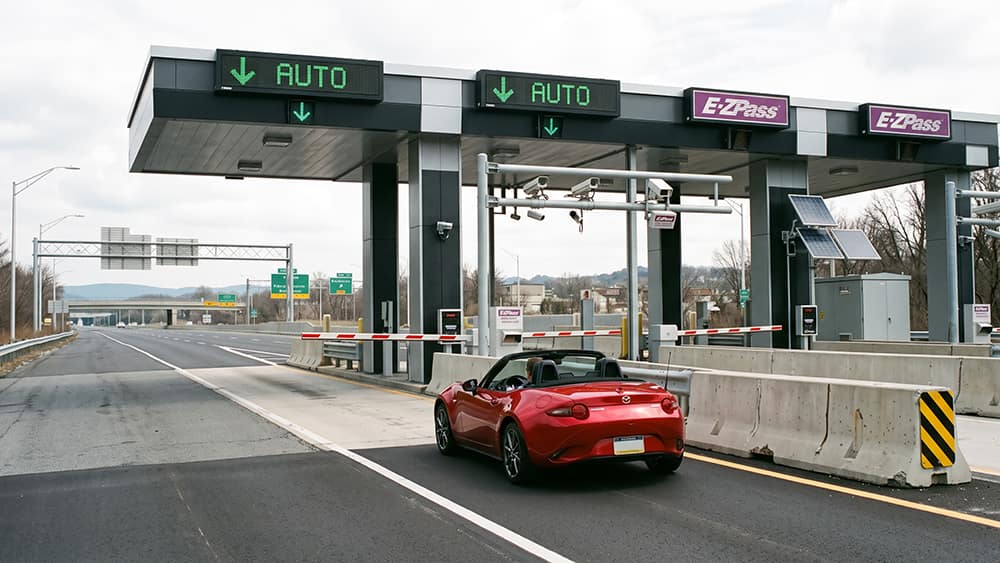 Convertible passing through an automated toll lane, where electrostatic ultrasonic sensors detect each vehicle.